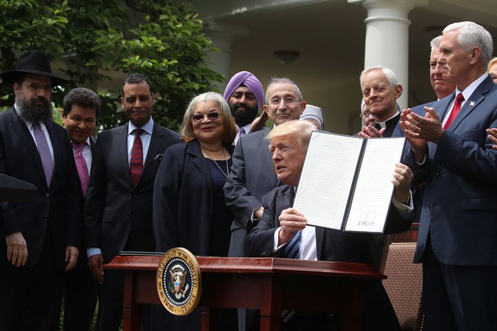 President Donald Trump is flanked by clergy members after signing an Executive Order on Promoting Free Speech and Religious Liberty, during a National Day of Prayer event in the Rose Harden at the White House, on May 4, 2017 in Washington, DC.