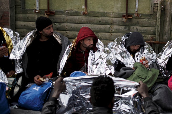 Refugees and migrants are covered with thermal blankets and receive food following a rescue operation at open sea near the island of Chios, Greece, on March 16.