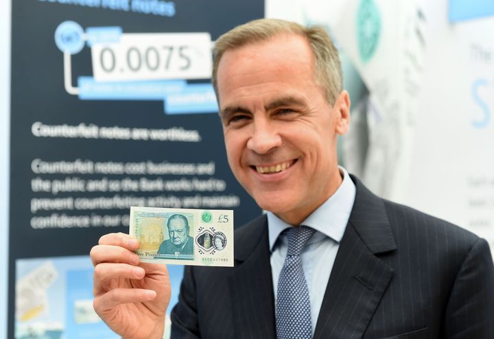 Governor of the Bank of England Mark Carney with the new polymer £5 note featuring Sir Winston Churchill