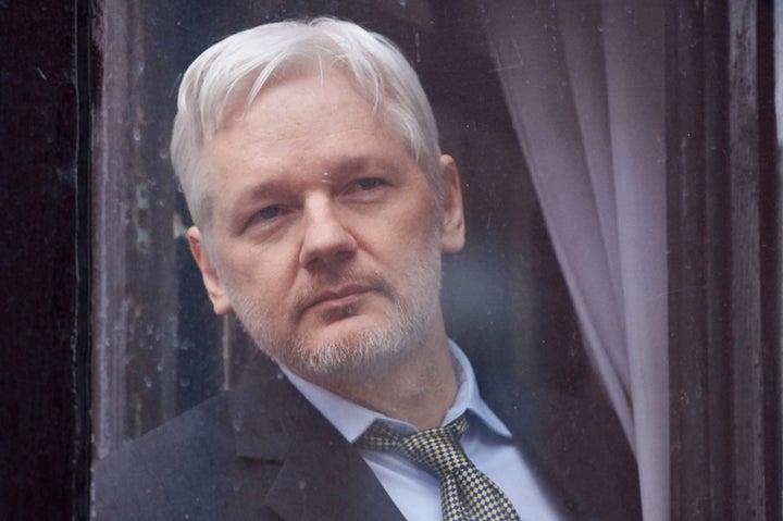 WikiLeaks founder Julian Assange looks out of the balcony window of the Ecuadorian embassy in central London on February 5, 2016 before addressing the media from the balcony.