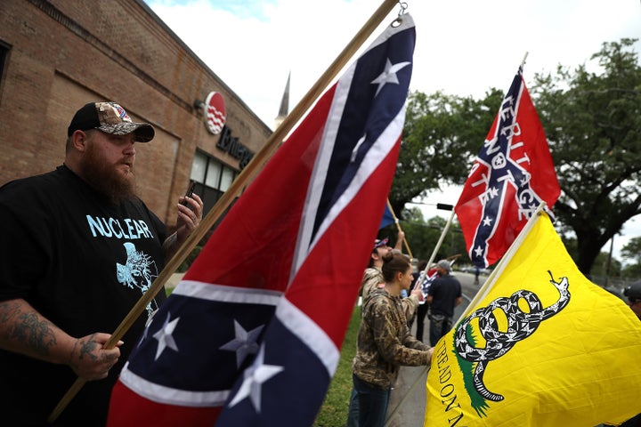 Protesters hold flags across the street from the Jefferson Davis monument on May 4, 2017 in New Orleans, Louisiana.