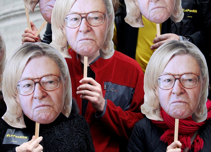 Activists wear masks of Jean-Marie Le Pen, founder of the National Front, with his daughter’s hair, Marine, currently the ext