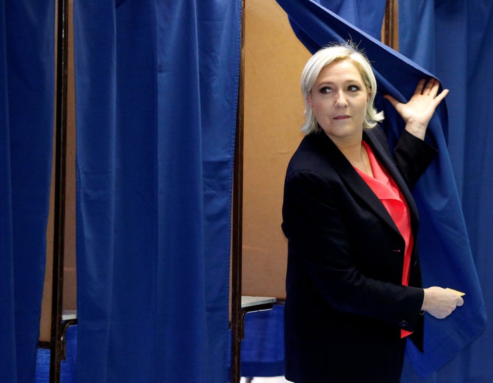 Le Pen exits a voting booth after casting her ballot.