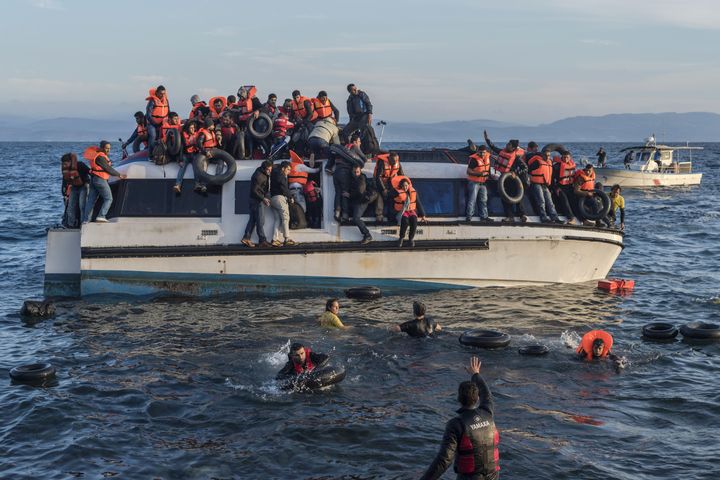 Syrian and Iraqi refugees reach the coastal waters of Lesbos in Greece, after having crossed from Turkey. 