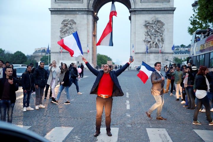 A man shouts as he waves a French national flag on the French avenue of the Champs Elysees by the Arc de Triomphe on May 7.