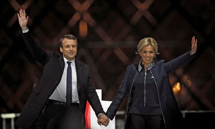 French President elect Emmanuel Macron and his wife Brigitte Trogneux celebrate on the stage at his victory rally near the Louvre in Paris yesterday.
