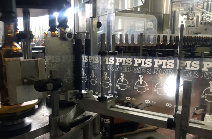 A picture of Pisner beer being labeled. 