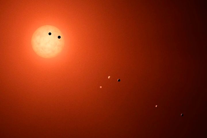 An illustration shows the seven TRAPPIST-1 planets as they might look as viewed from Earth.