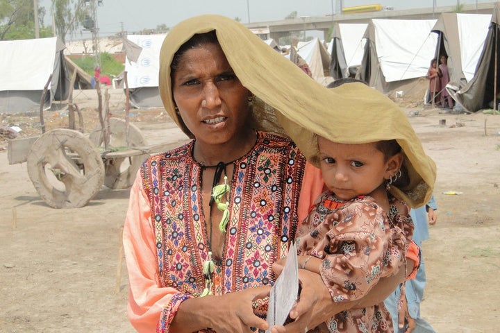 In Pakistan’s Sindh province, a mother tries to shield her four-year-old daughter from scorching heat. 