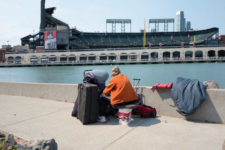 A woman with her belongings looks over at AT&T Park in San Francisco.