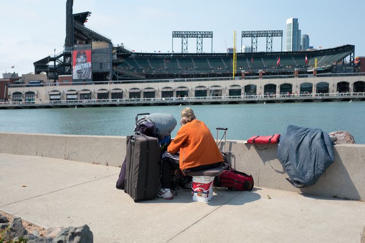 A woman with her belongings looks over at AT&T Park in San Francisco.