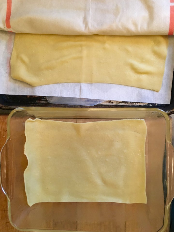 <p>The first layer of blanched pasta in a buttered oven dish</p>