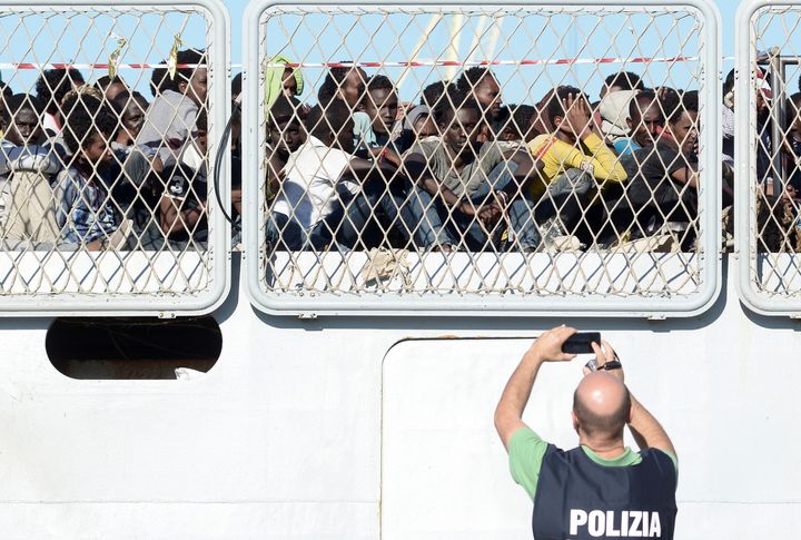 Migrants wait to disembark an Italian Navy ship in the Sicilian harbor of Palermo, southern Italy, on July 20, 2016.