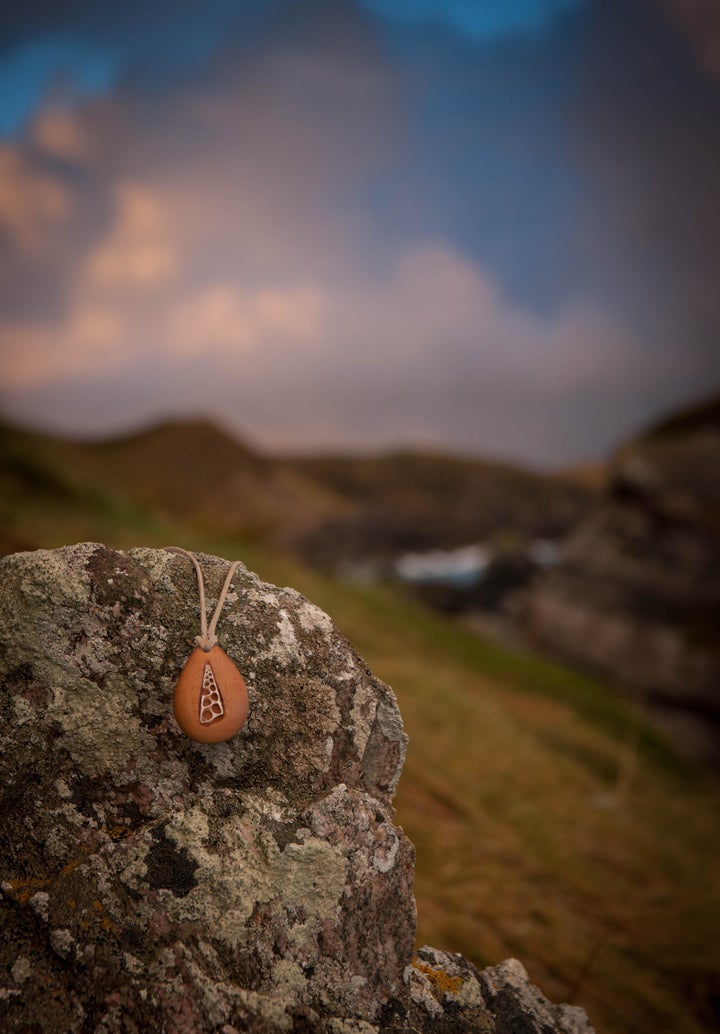 "I made the necklace with two small bits of Huon pine glued together with a thin sheet of paper between them (and a space carved out for the ring to fit into). The glue held it together but the paper acted like a seam that I could split open with a knife," Terry explained. 