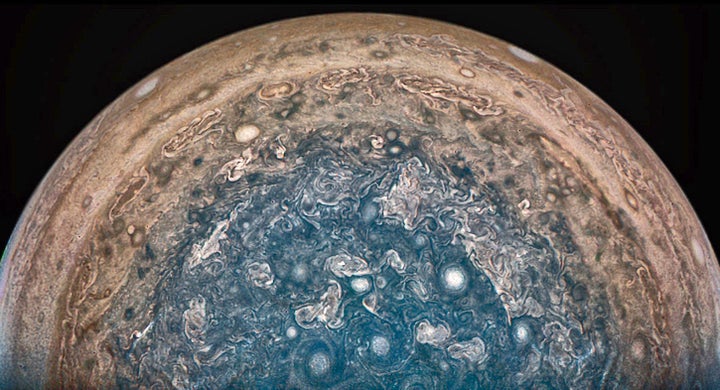 In this enhanced-color view of Jupiter’s south pole, photographed by the Juno spacecraft, numerous oval storms -- some as big as Earth -- can be seen among the cloudscape.