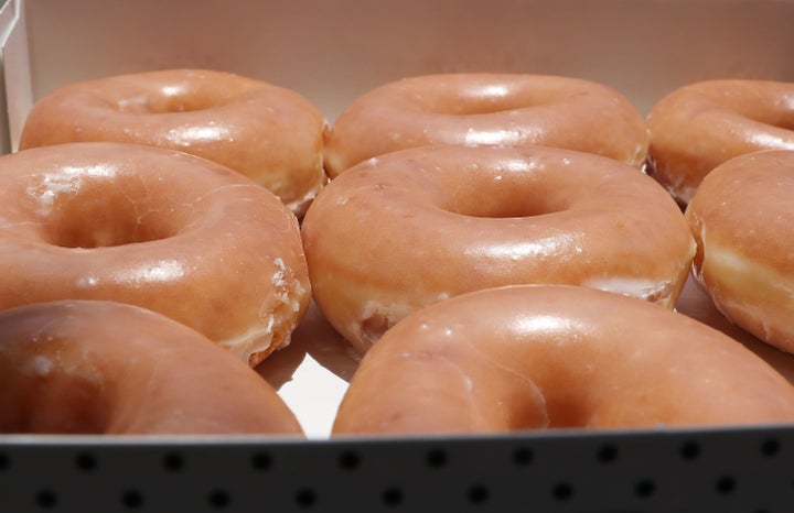 A closeup of a box of Krispy Kreme glazed donuts.