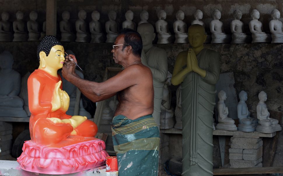 A Sri Lankan artist works on Buddhist statues ahead of the Vesak Festival in Dompe, on the outskirts of Colombo on May 7, 2017.