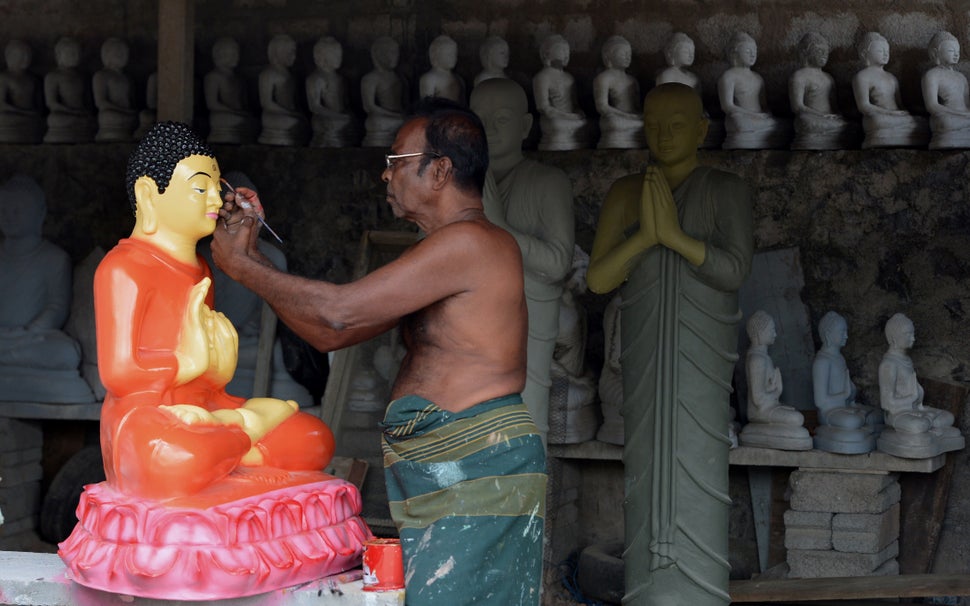 A Sri Lankan artist works on Buddhist statues ahead of the Vesak Festival in Dompe, on the outskirts of Colombo on May 7, 2017.