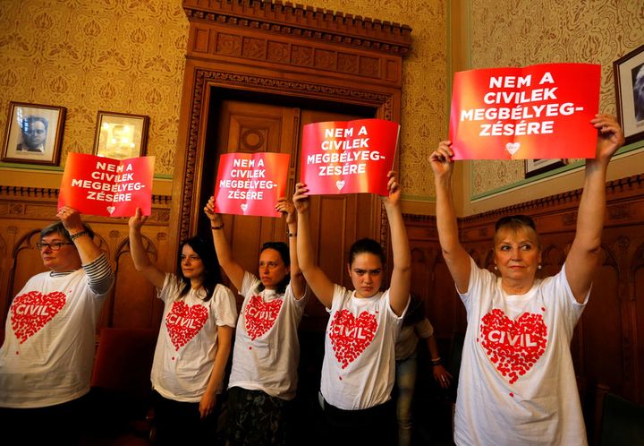 Protestors hold banners saying ‘No to the stigmatisation of civilians’ at a meeting of the Hungarian parliament’s justice committee.
