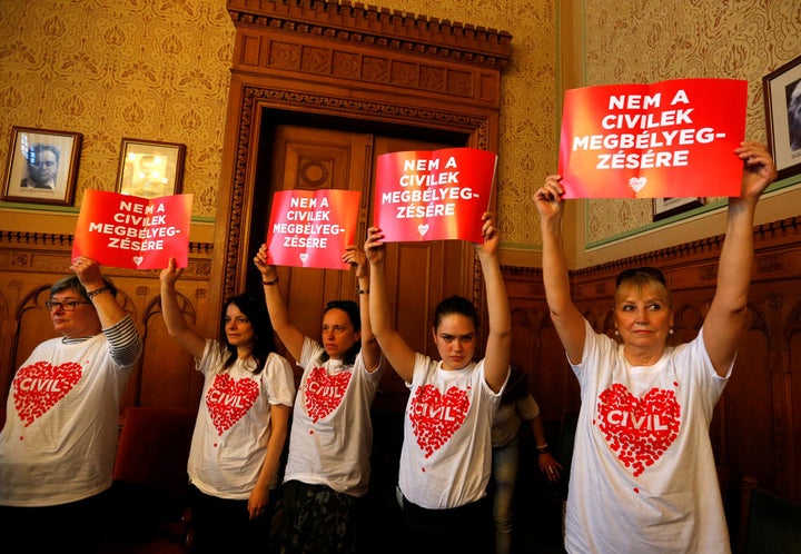 Protestors hold banners saying ‘No to the stigmatisation of civilians’ at a meeting of the Hungarian parliament’s justice committee.