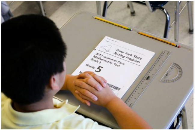 <p>A fifth-grade student in Roosevelt, New York with the Common Core mathematics test booklet.</p>