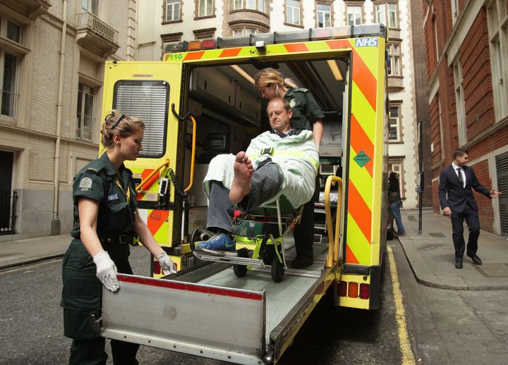 BBC cameraman Giles Wooltorton is loaded into an ambulance after the car carrying Jeremy Corbyn ran over his foot