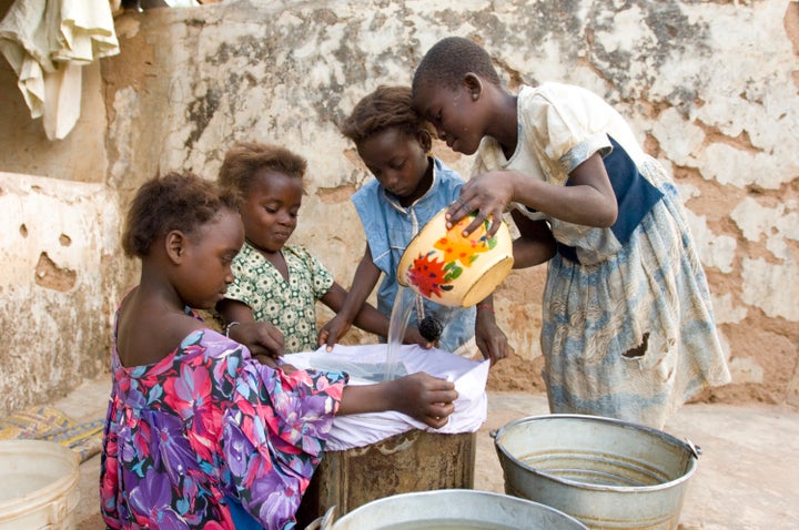 Girls who previously suffered from Guinea worm filter their drinking water to prevent the disease.