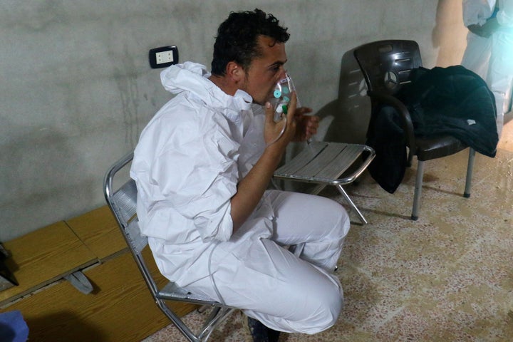 A man breathes through an oxygen mask, after what rescue workers described as a suspected gas attack in the town of Khan Shei