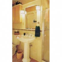 The 34x37-in. shower in this remodeled bath occupies a former closet. A pedestal sink in place of the vanity opens more floor to view. Other space-creating effects include light-colored finish materials, a dark floor and light ceiling and plenty of artificial-light sources. Shallow cabinets installed high on the wall provide storage.