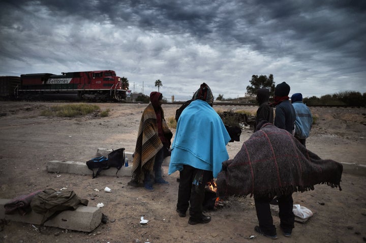 Honduran migrants warm themselves next to a campfire in Sonora, Mexico, on Jan. 13, 2017.