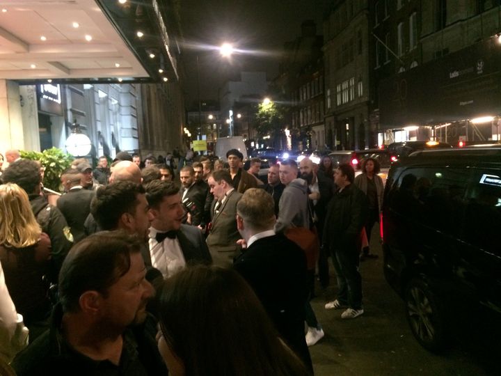 Groups of passersby and photographers crowd the entrance of the Connaught Rooms venue, left, just seconds after Jenner got into a car, right