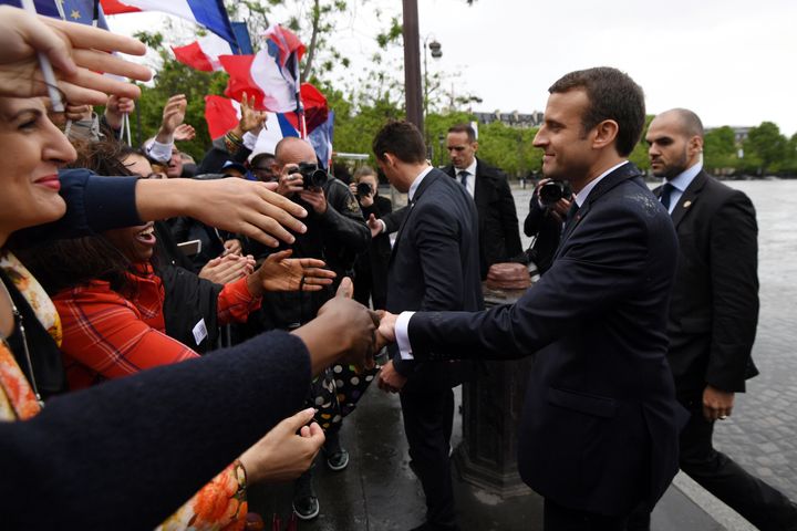 French President Emmanuel Macron (R) greets people in the crowd after attending a ceremony at the Tomb of the Unknown Soldier at the Arc de Triomphe in Paris.