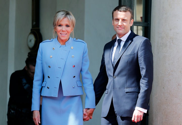 Newly-elected President Emmanuel Macron and his wife Brigitte Trogneux pose on the steps of the Elysee Palace after the handover ceremony with France's outgoing President Francois Hollande. 