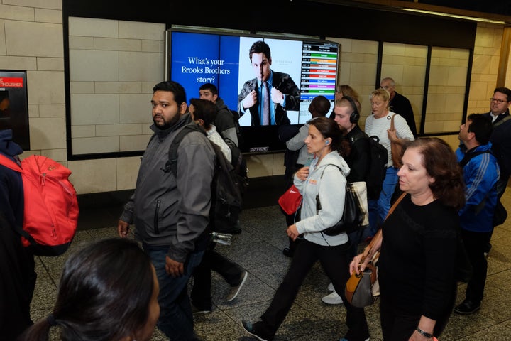 <p>Digital screen displays train info . . . and Brooks Brothers advertisement in New York City</p>