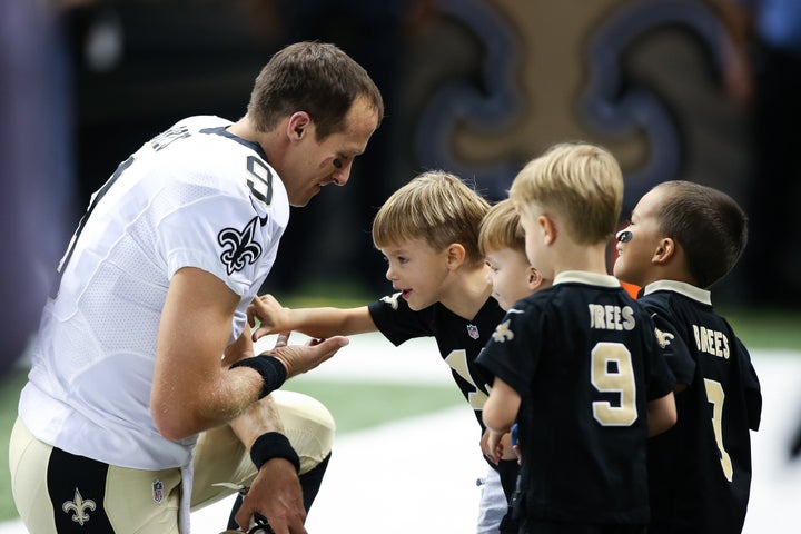 Brees pauses on the sideline with his family before an August 2015 game.