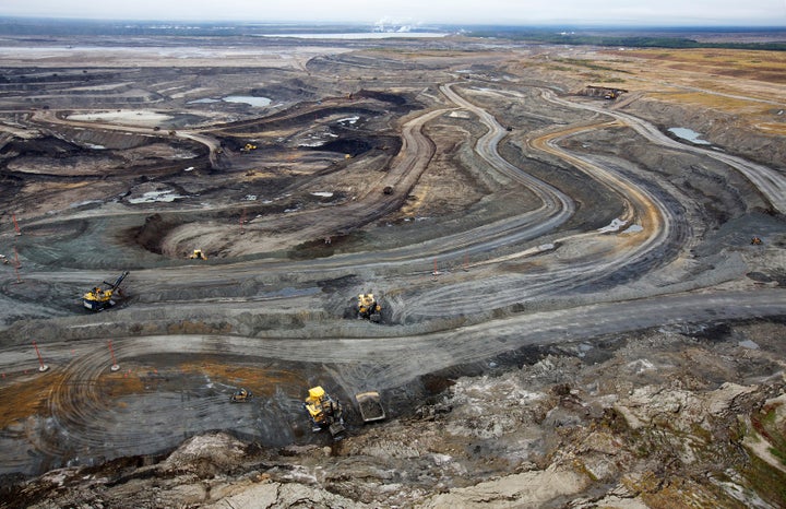 Giant dump trucks haul raw tar sands to be processed at the Suncor tar sands mining operations near Fort McMurray in Alberta, Canada in 2014.