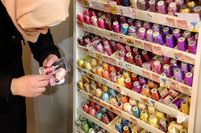 A Syrian woman selects thread to make earnings for Drop Earrings, Not Bombs, an income-generation and community-building project in Istanbul.