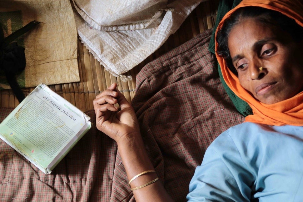 Rucia Begum awaits treatment. She lives in a recently constructed hut with six other members of her family, including her mot