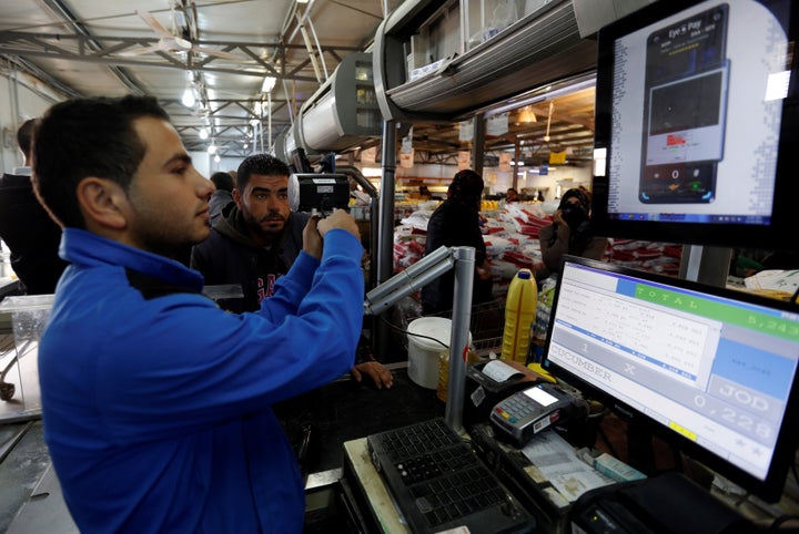 A Syrian refugee uses an IrisGuard machine to verify his identity and receive food aid at the Tazweed center in Jordan's Zaatari Refugee Camp in November 2016.