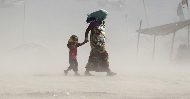 <p>A mother and her child walk along the Ganges river during a dust storm on a hot summer day in Allahabad, India, June 9, 2015.</p>