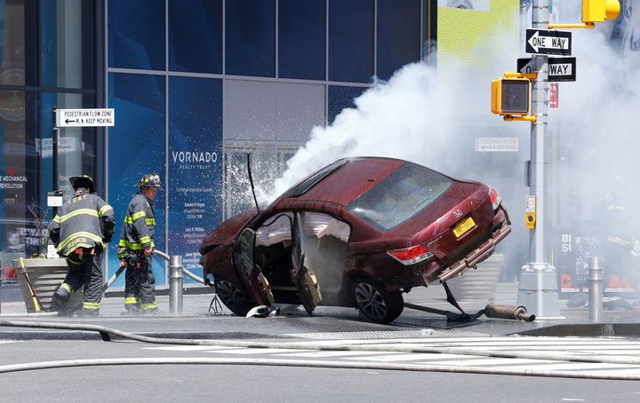 Flames and smoke rises from a wrecked vehicle after it ploughed into pedestrians on a busy sidewalk on the corner of West 45th St. and Broadway at Times Square, New York