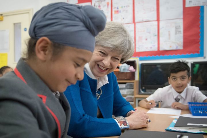 Theresa May with eight-year-old Akaal Singh at Nishkam Primary School in Birmingham 