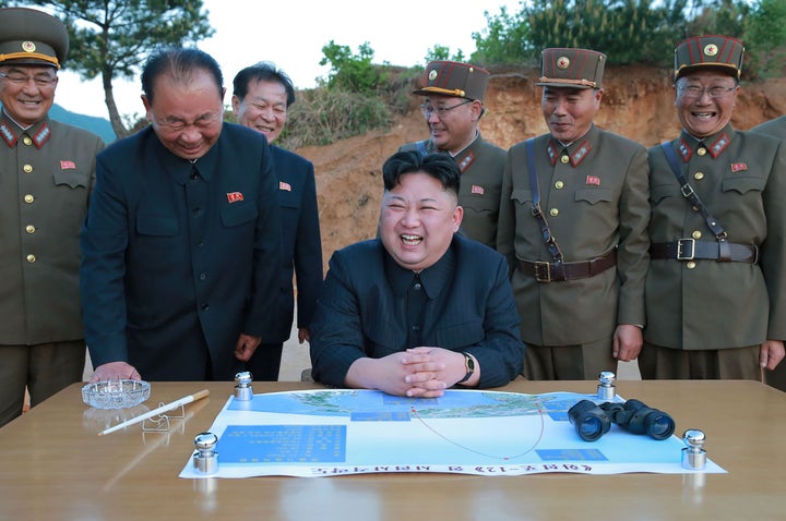 North Korean leader Kim Jong-un laughs during a test launch of a ground-to-ground medium long-range strategic ballistic rocket.