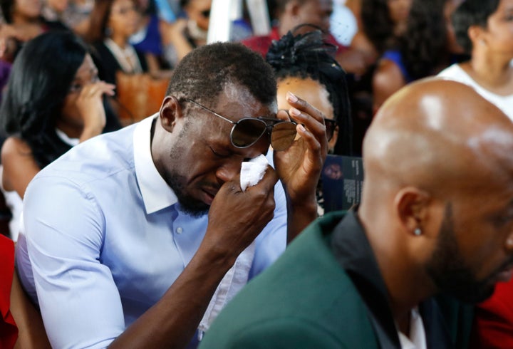 Bolt wipes tears from his eyes during the service for Mason at the Seventh Day Adventist Church, in Kingston