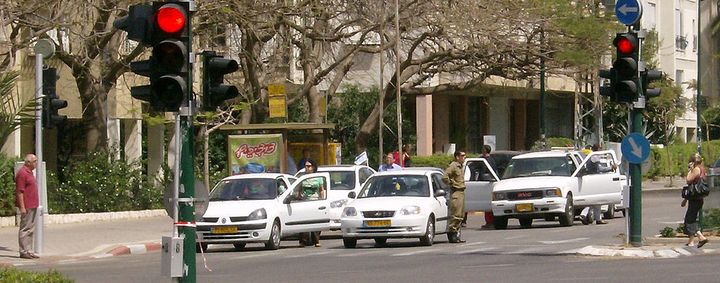 Drivers in Tel Aviv stand at attention beside their cars during the siren