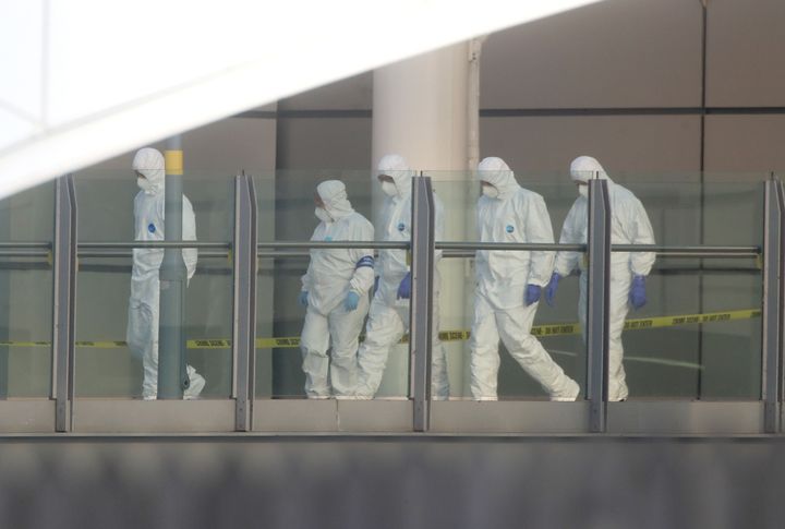 Police forensic investigators walk along a bridge linking Victoria Station with the Manchester Arena