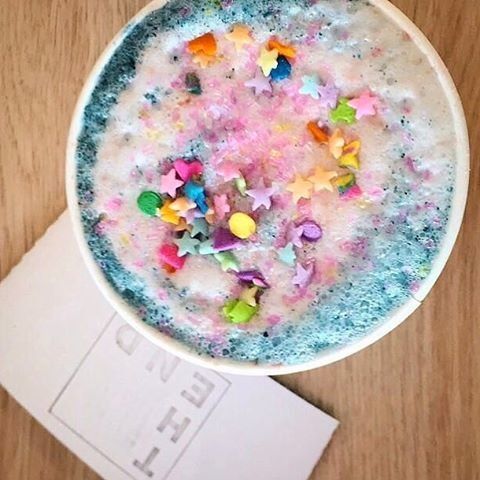 A colorful unicorn latte, covered in sprinkles.