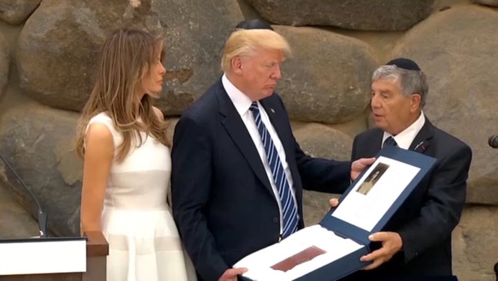 A still image taken from video shows Yad Vashem Chairman Avner Shalev presenting to U.S. President Donald Trump and first lad
