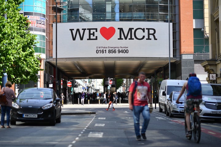 A sign that reads "We Love MCR" is displayed in solidarity above a street in central Manchester, northwest England.