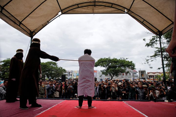 Up to 1,000 people, many filming with smartphones, watched as the two men received 82 lashes each. 
